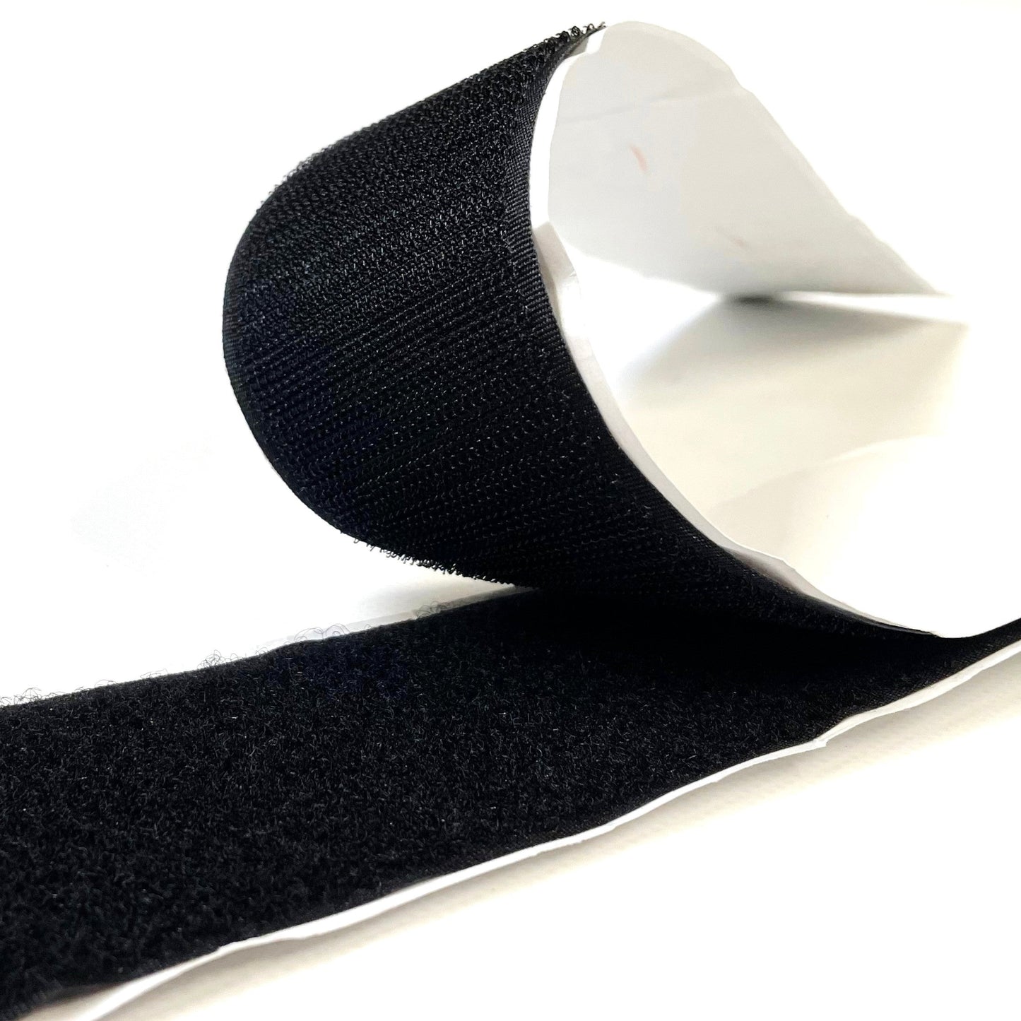 A roll of black self-adhesive interlocking hook and loop tape, 38mm wide.
